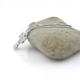 a silver cross on a necklace