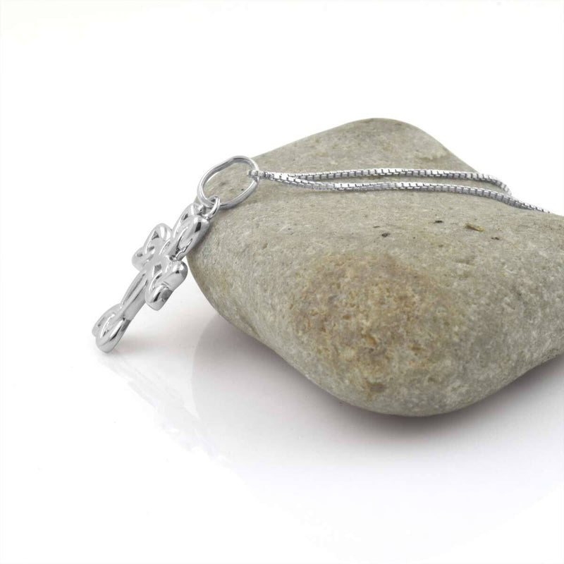 a silver cross on a necklace
