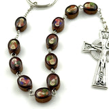 Rosary keychain featuring the Saints of Ireland on a white foreground with a stone in the background.
